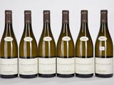 six bouteilles de vin sont alignées sur une table