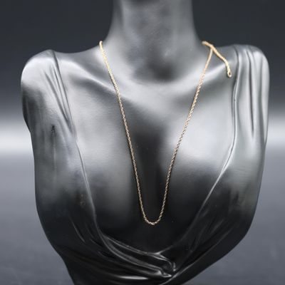 a mannequin head with a gold necklace on it