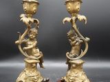 paire de bougeoirs anciens en laiton reposant sur des socles en marbre rouge