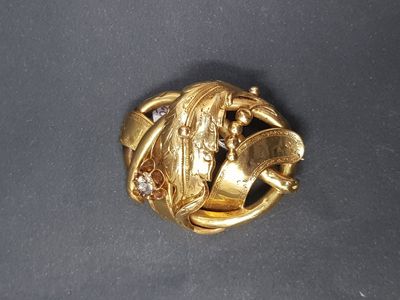 une photo d'une broche en or ornée d'un dragon