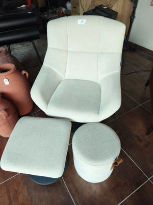 un fauteuil, un pouf et un autre pouf dans un salon