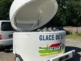 un camion de glaces blanc avec un grand conteneur à l'arrière