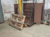 a pile of pallets in a warehouse with a door open