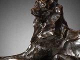 bronze sculpture of a lion resting on a marble base