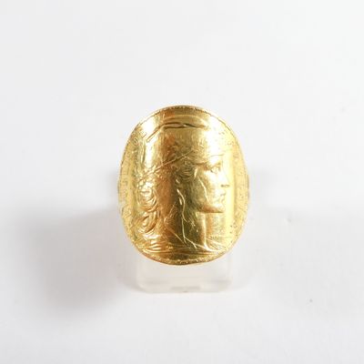 une image représentant une bague en or sur laquelle figure le visage d'une femme