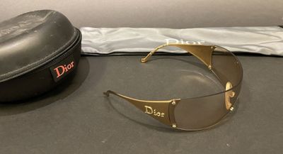 christian dior sunglasses and case on a table next to a bag