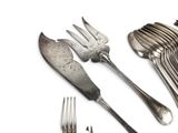 a lot of forks and spoons that are sitting on a table