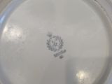 a white plate with a crest on it sitting on a table