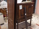 une armoire en bois au milieu d'une pièce, avec une échelle devant