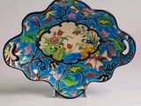 une assiette bleue ornée d'un motif représentant des fleurs et des oiseaux