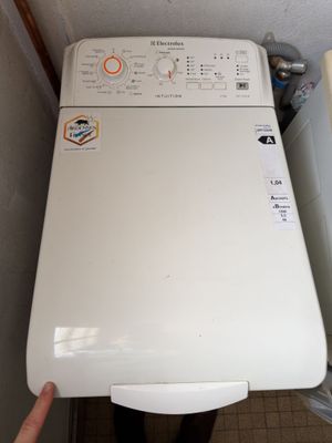 a white washer sitting next to a white toilet in a bathroom
