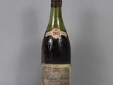 une vieille bouteille de vin posée sur une table en verre