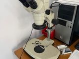 a microscope sitting on a desk next to a computer