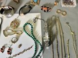many different types of necklaces and bracelets laid out on a table