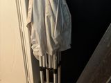 un manteau blanc accroché au mur à côté d'une paire de skis