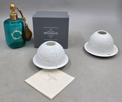 two white dishes and a blue bottle on a table