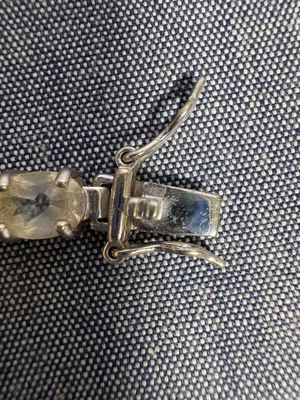 un gros plan d'un bracelet en argent orné d'une pierre en cristal