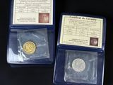 three different types of gold coins in plastic cases on a black surface