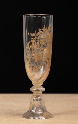 un verre orné d'un motif doré, posé sur une table