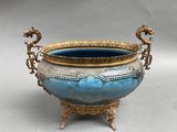 a blue and gold vase with a dragon handle on a stand