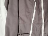 a close up of a jacket on a bed with a tag on it