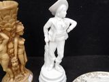 three plates and a figurine on a black table