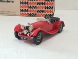 a red model of a car on a white surface