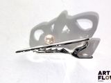 a pair of scissors and a pearl on a white surface