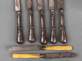 six knives are lined up on a table next to each other