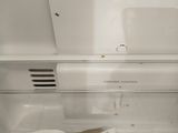 an open refrigerator door with a book inside of it