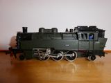 un petit train miniature posé sur une table en bois