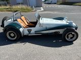 une petite voiture verte et blanche garée sur un parking