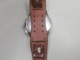 wrist watch with brown leather strap on white surface