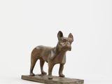 statue d'un bouledogue français posée sur un socle en marbre