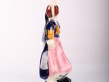 a figurine of a woman in a pink dress