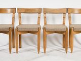 three wooden chairs sitting next to each other on a white surface