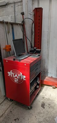 une petite machine rouge sur laquelle est posé un ordinateur portable