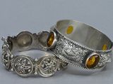 pair of silver bracelets with citrine stones on them