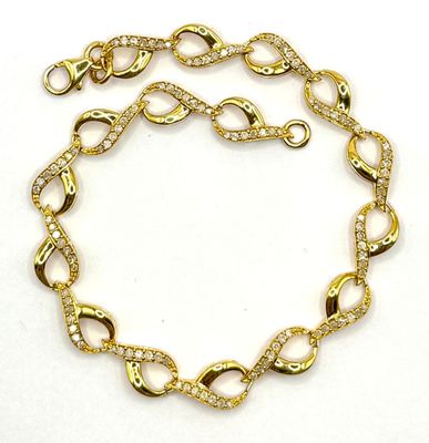 gros plan d'un bracelet en chaîne en or sur fond blanc