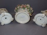 three white porcelain vases with flowers on them sitting next to each other