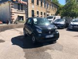 a small black car parked in front of a building