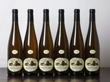 six bouteilles de vin sont alignées sur une table en bois