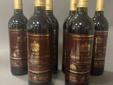 six bouteilles de vin sont alignées sur une table