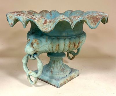 a blue vase with a handle on it on a table