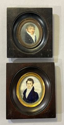 Deux portraits encadrés, représentant un homme et une femme, sont exposés