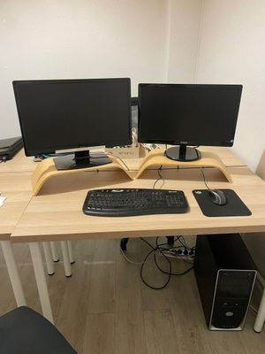 a desk with two monitors and a keyboard on it