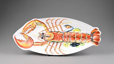 a plate with a lobster on it on a gray surface