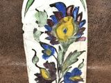 un vase blanc orné de fleurs bleues et jaunes