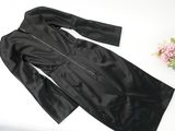 black leather jacket on a white table next to a vase of flowers