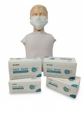trois boîtes de masques faciaux et une tête de mannequin sur fond blanc